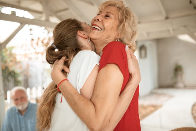 Life Stages Smiling older woman hugging a younger woman, representing confidence and connection at different stages of life